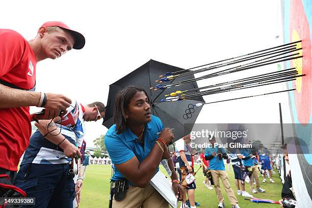 Larry Godfrey of Great Britain, Jacob Wukie of the United States and Jayanta Talukdar of India retrieve their arrows during the Archery Ranking Round...