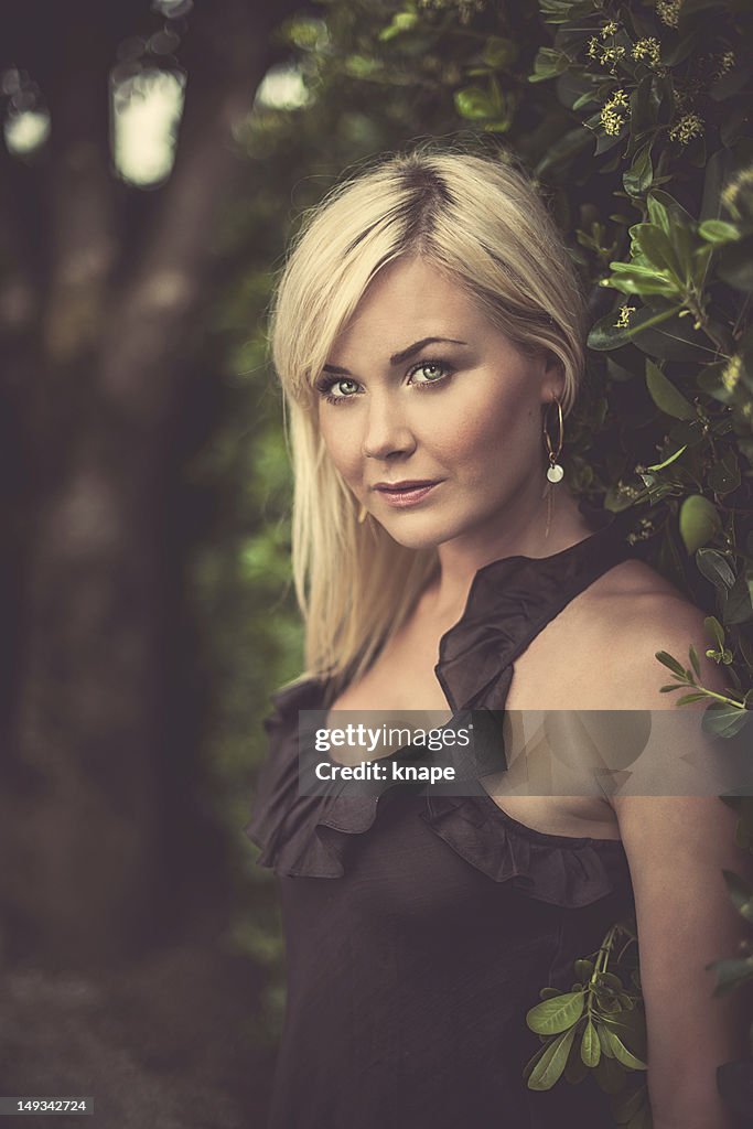 Beautiful woman by a hedge