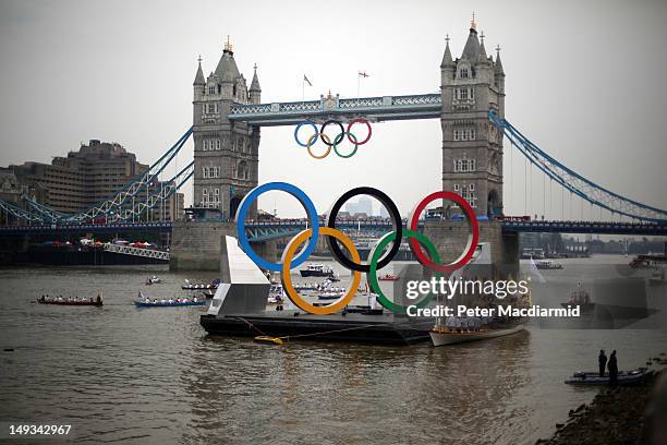 Torch bearer Amber Charles stands under giant Olympic rings next to Tower Bridge on the final day of the London 2012 Olympic Torch Relay on July 27,...