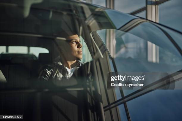 young man inside of a car in a showroom. - introspection stock pictures, royalty-free photos & images