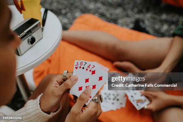 top down image of two woman playing a game of cards on a beach - solitaire stock pictures, royalty-free photos & images