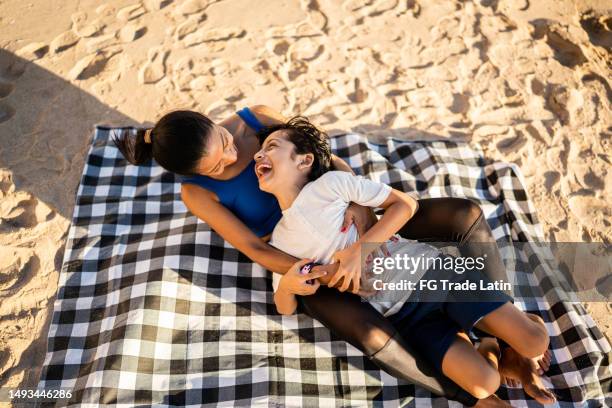 madre e hijo divirtiéndose y haciendo cosquillas en la playa - mexican picnic fotografías e imágenes de stock