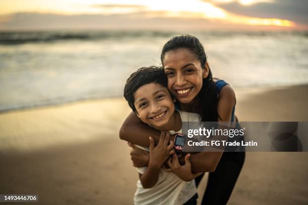 portrait of mother and son embracing by the ocean - mexican mothers day 個照片及圖片檔