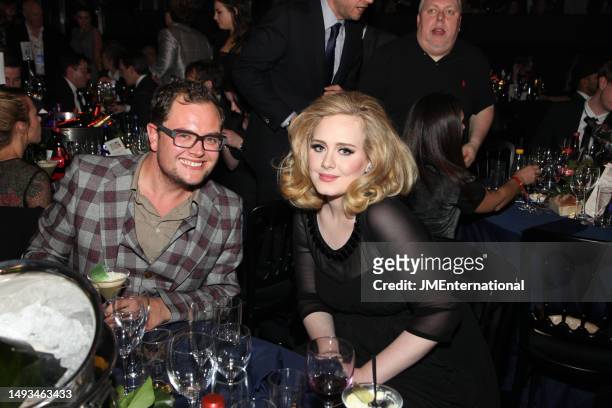 Alan Carr and Adele pose at tables during The BRIT Awards 2012 at The O2, on February 21, 2012 in London, England.