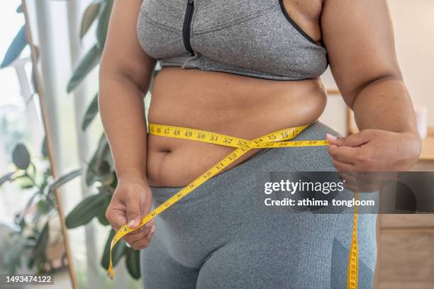 plus size female holds measures tape check her waist size. - woman measuring tape stock pictures, royalty-free photos & images