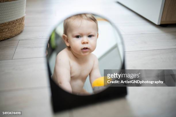 schönes baby, das in den spiegel schaut. - bedroom mirror stock-fotos und bilder