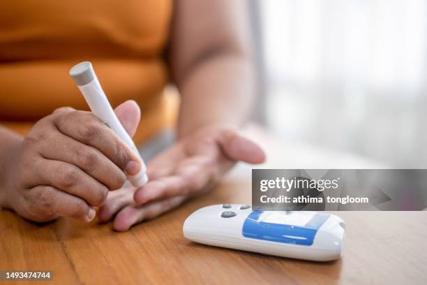 blood sugar finger prick testing with portable glucometer. - diabetes pictures stock-fotos und bilder