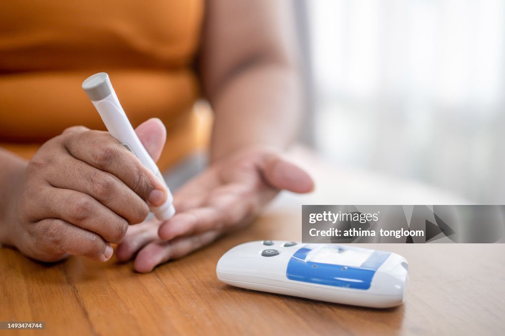 Blood sugar finger prick testing with portable glucometer.