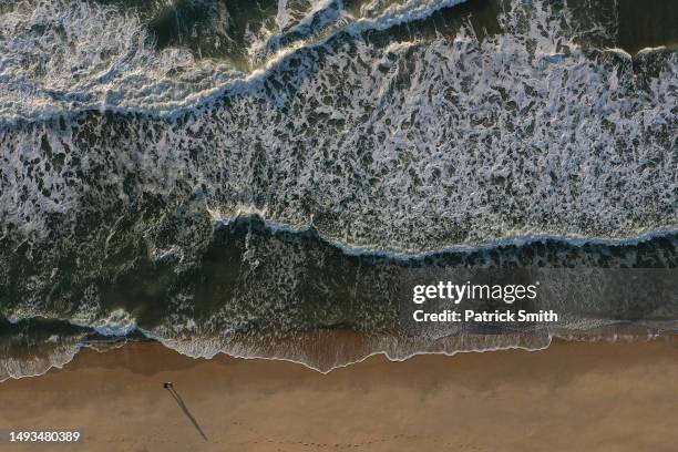 In an aerial view, a person walks in the beach on May 26, 2023 in Ocean City, Maryland. Memorial Day Weekend marks the start of beach season on the...