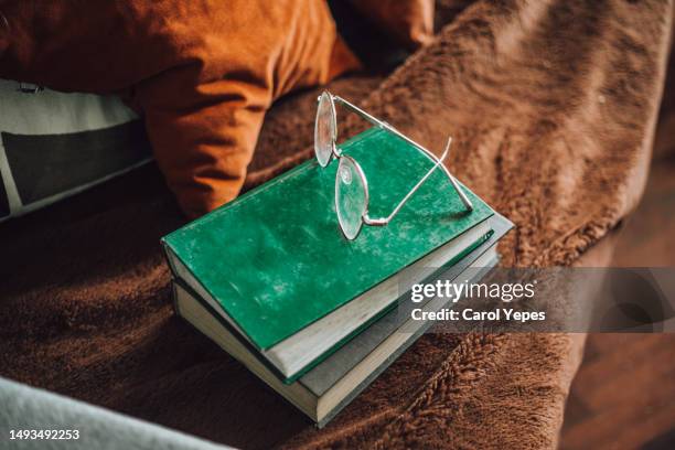 top down pile of books and eyeglasses - bedside table top view stock pictures, royalty-free photos & images
