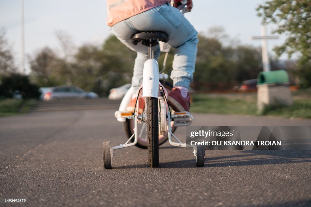 Bike Riding Lessons Rear View Rear View Of Child Learning To Ride Bike With Training Wheels High-Res ...