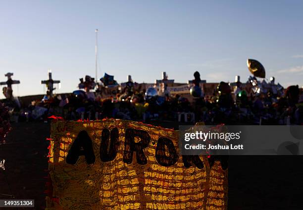 Crosses and a banner are lit by the morning light at a memorial across the street from the Century 16 movie theatre July 27, 2012 in Aurora,...