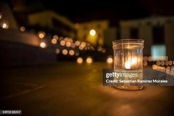 many lighted candles in an urban environment, with bokeh on the horizon of the image. - mémorial photos et images de collection