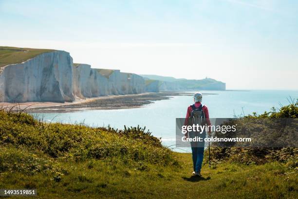 senior man hiking on country path leading to seven sisters cliffs in southern england - south downs national park stock pictures, royalty-free photos & images