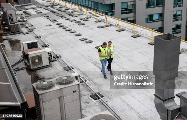 maintenance engineers doing a routine inspection on the rooftop of a building - condição imagens e fotografias de stock