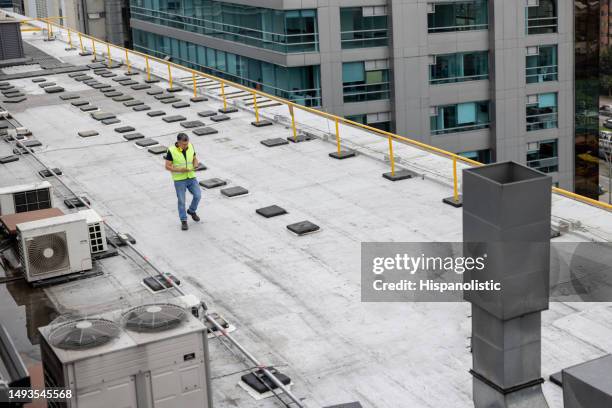 ingeniero de mantenimiento haciendo una inspección de rutina en la azotea de un edificio - calidad fotografías e imágenes de stock