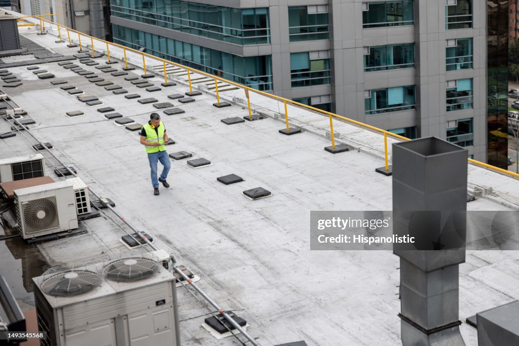 Maintenance engineer doing a routine inspection on the rooftop of a building