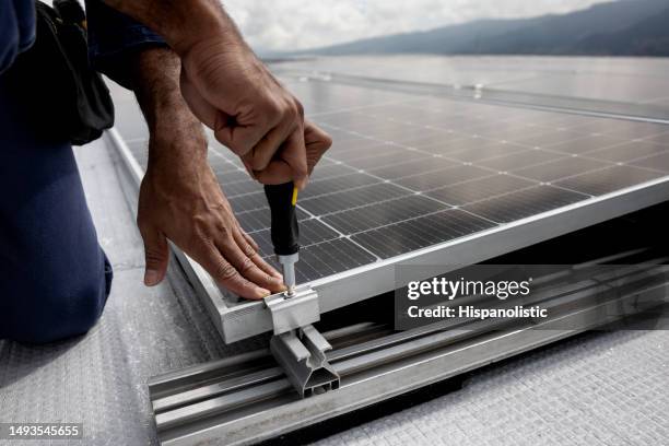 power engineer installing solar panels on a rooftop - screwdriver stock pictures, royalty-free photos & images