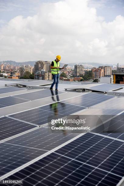 ingenieur, der die niveaus der stromversorgung von sonnenkollektoren liest - solar panel city stock-fotos und bilder