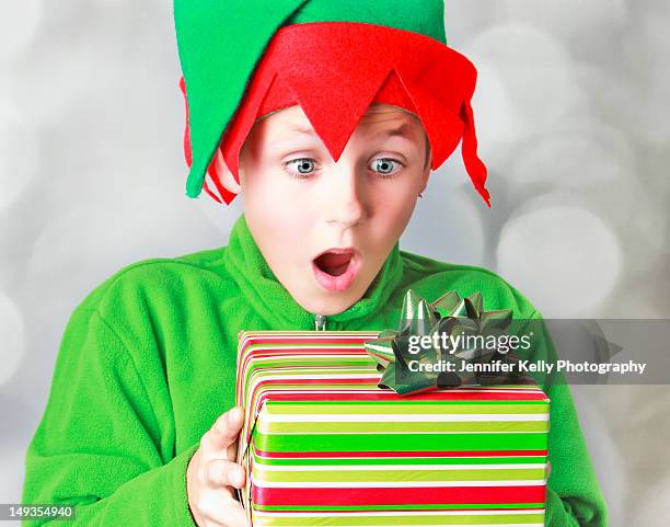 surprised blue eyed little boy elf with gift - jennifer kelly stock pictures, royalty-free photos & images