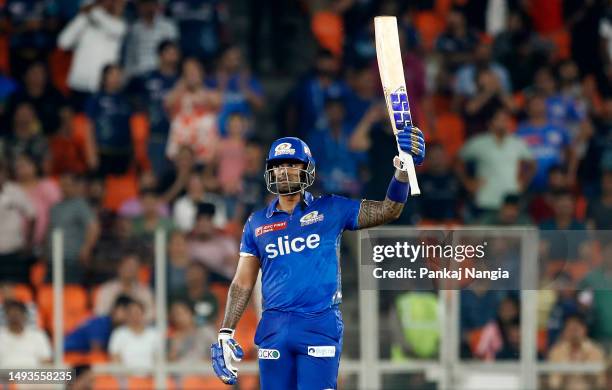 Surya Kumar Yadav of Mumbai Indians raises his bat to the crowd as he celebrates after scoring a half century during the IPL Qualifier match between...