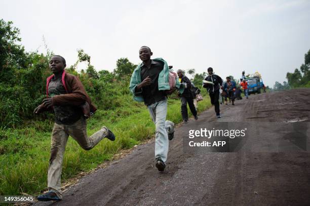 Civilians flee heavy gunfire on the road leading from Rugari to Kibumba in the east of the Democratic Republic of Congo on July 27, 2012. Gunfire...
