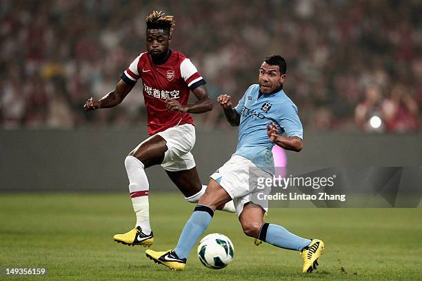 Carlos Tevez of Manchester City challenges Alex Song of Arsenal FC during the pre-season Asian Tour friendly match between Arsenal and Manchester...