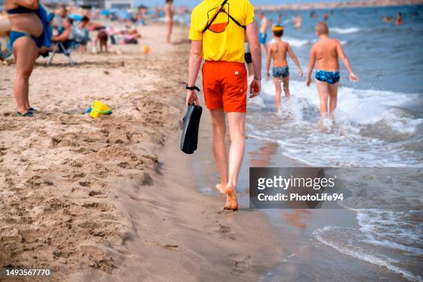 baywatch patrols the beach - red guards stockfoto's en -beelden
