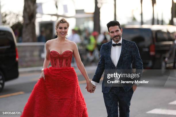 Verena Kerth seen wearing a wide red bandeau dress, Cartier love bracelet and Cartier juste un clou and Marc Ternezi seen wearing a dark blue suit...