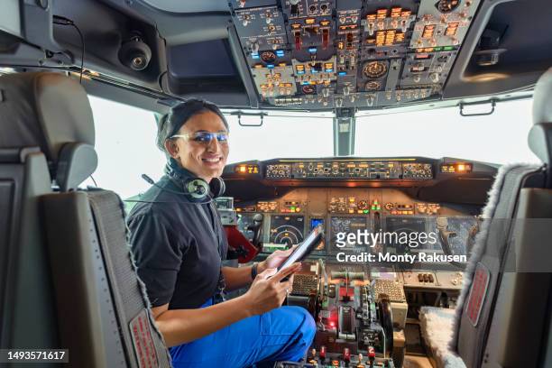 portrait of avionics technician checking cockpit in aircraft maintenance factory - aerospace engineering stock pictures, royalty-free photos & images