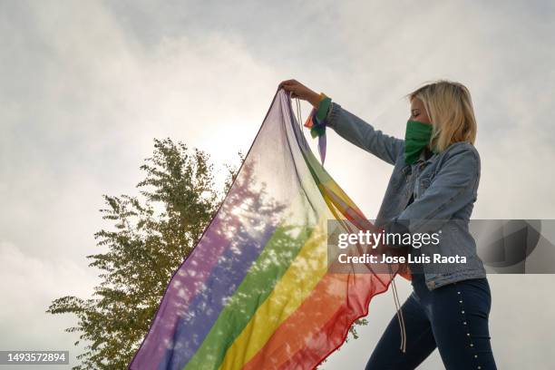 anonymous woman holding lgbtq rights sign - marching icon stock pictures, royalty-free photos & images
