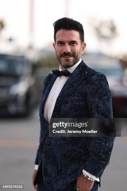 Marc Ternezi seen wearing a dark blue suit with flower pattern, a white shirt, a bow tie and black white leather shoes during the 76th Cannes film...