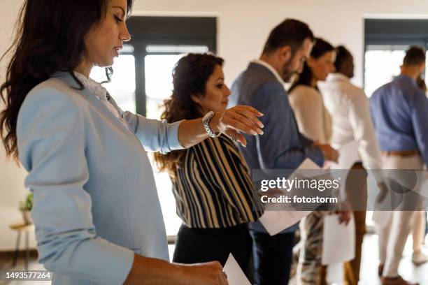 businesswoman looking at time while waiting in line - candidates for time person of the year 2014 stockfoto's en -beelden