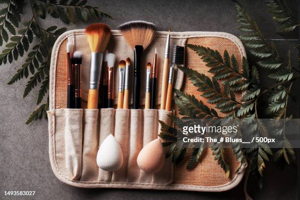 high angle view of make-up brushes in container on table - geschminkt gezicht stockfoto's en -beelden