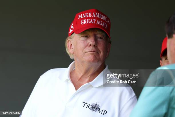 Former US President Donald Trump watches from a box on the 18th green during day one of the LIV Golf Invitational - DC at Trump National Golf Club on...