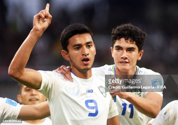 Shakhzodjon Nematjonov of Uzbekistan celebrates with Sherzod Esanov and teammates after scoring the team's first goal during a FIFA U-20 World Cup...