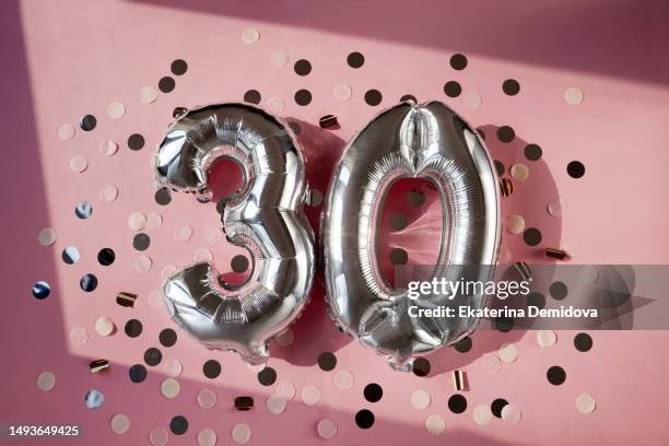 silver numbers 30 thirty years balloons in sunlight pink background - zahl 30 stock-fotos und bilder