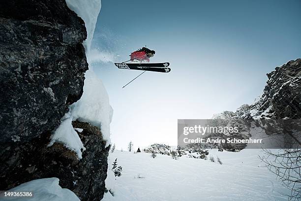 skier jumping of a cliff - wintersport stock-fotos und bilder