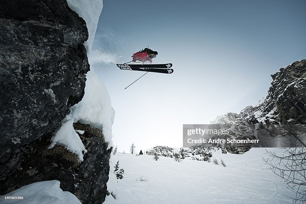 Skier jumping of a cliff