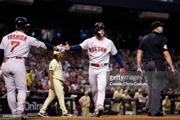 Alex Verdugo of the Boston Red Sox high fives Masataka Yoshida after scoring a run during the sixth inning against the Arizona Diamondbacks at Chase...