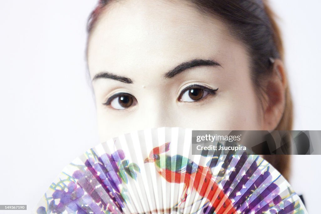 Portrait of young woman with fan