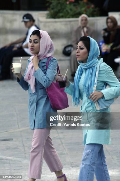 Young Iranian women walk at a shopping mall in Tehran, June 1, 2005. In the heart of Iran, a new generation emerges, embodying resilience, ambition,...