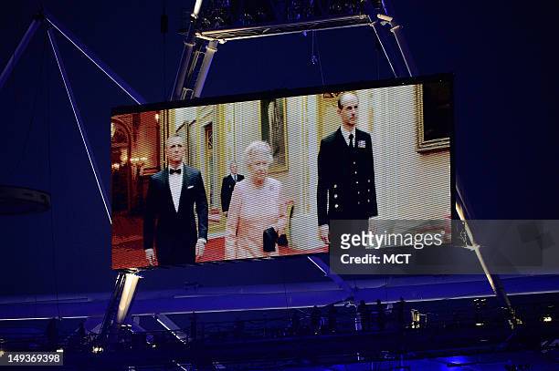 Queen Elizabeth II appears on a large video screen accompanied by Prince Philip, right, and actor Daniel Craig during the Opening Ceremony for the...