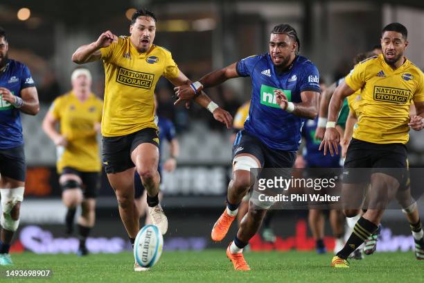 Billy Proctor of the Hurricanes chases the loose ball with Hoskins Sotutu of the Blues to score a try during the round 14 Super Rugby Pacific match...