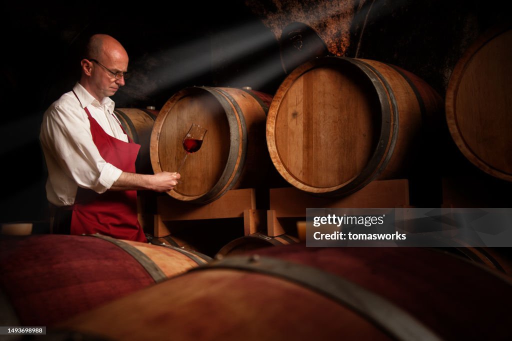Winemaker is exam his product at Wine cellar