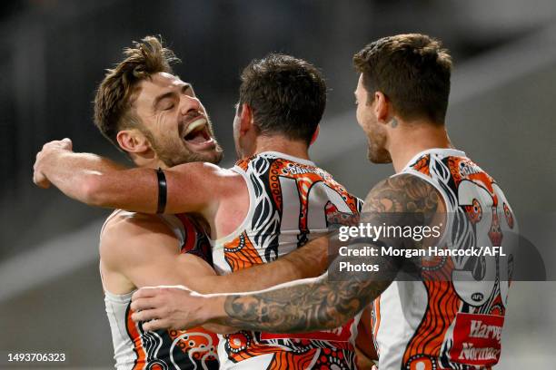 Stephen Coniglio, Brent Daniels and Daniel Lloyd of the Giants celebrate a goal during the round 11 AFL match between Geelong Cats and Greater...