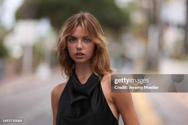 Charlotte Amelia Thomas seen wearing a black waterfall top, dark blue jeans pants and black leather shoes during the 76th Cannes film festival on May...