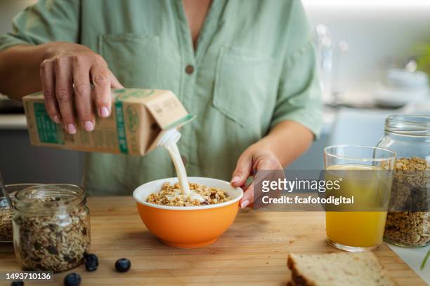 woman preparing healthy milk and muesli breakfast - carton milk stock pictures, royalty-free photos & images