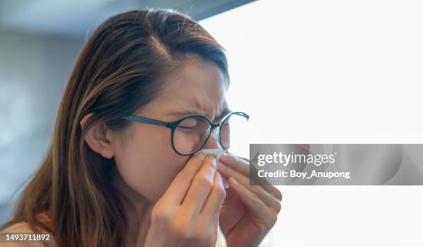 young asian woman sneezing. when foreign matter such as dirt, pollen, smoke, or dust enters the nostrils, the nose may become irritated or tickled. - nasal passage stock pictures, royalty-free photos & images