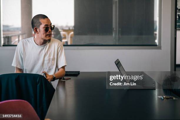 a young man sits in a conference room - aerial stunts flying stock pictures, royalty-free photos & images